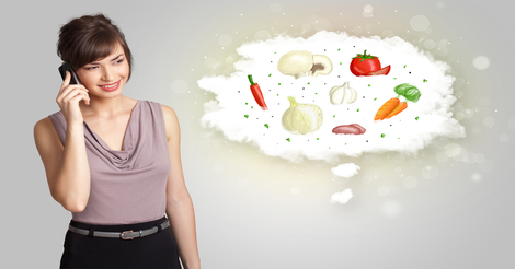 Pretty woman presenting a cloud of healthy nutritional vegetables